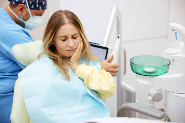 Patient holding jaw during a dental emergency consultation